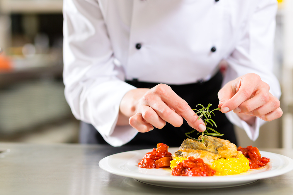 Chef slicing ingredients with AI-powered recipe suggestions on a tablet.