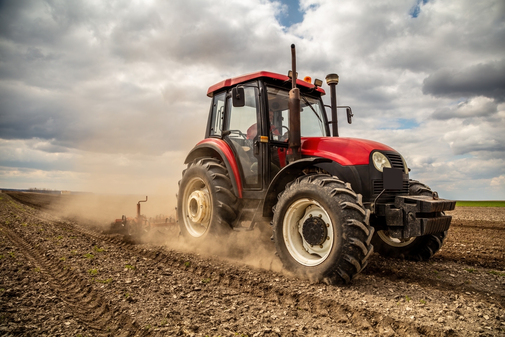 Farmer driving a smart tractor using AI field analytics.